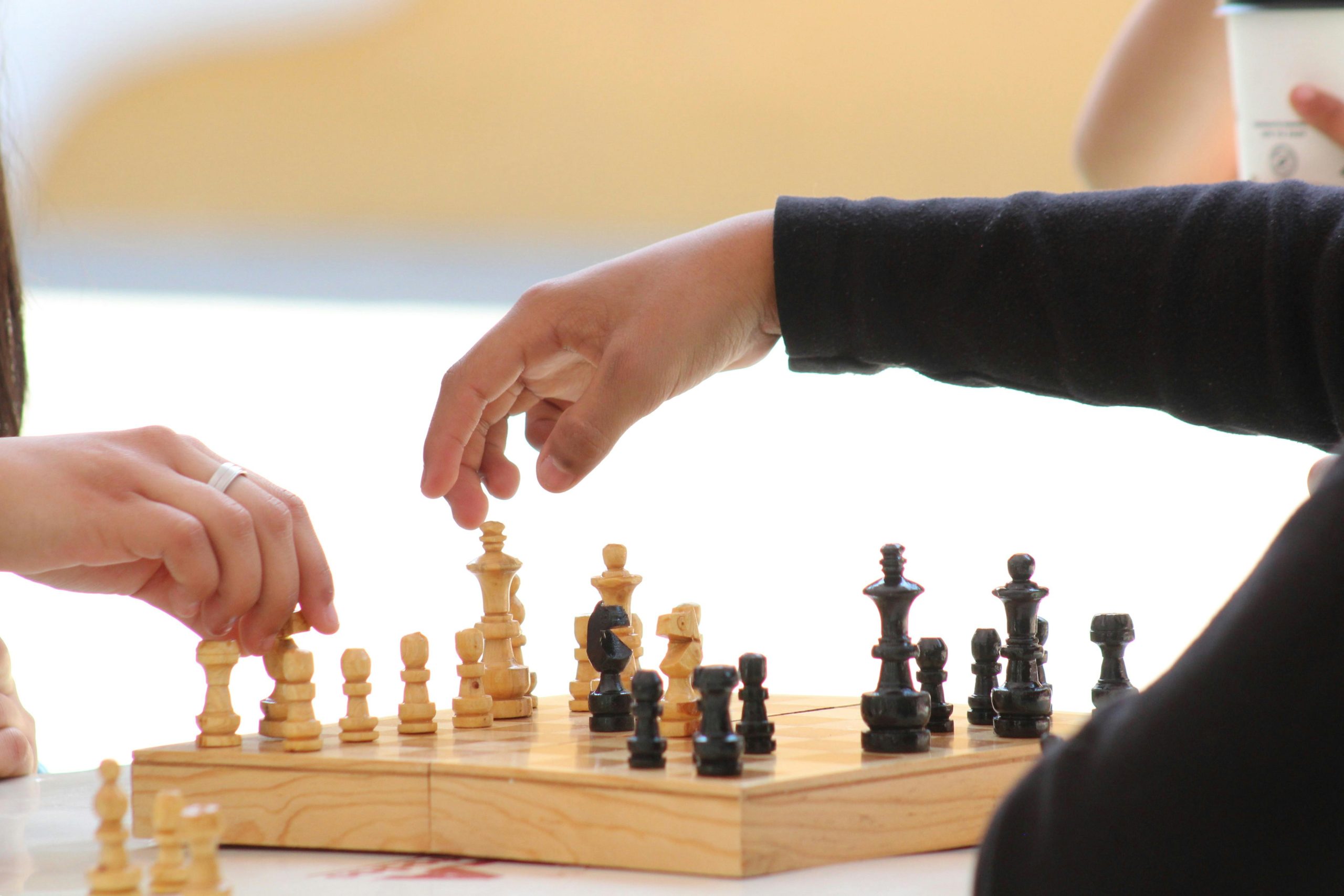Two players strategizing during a chess game, focusing on moves.